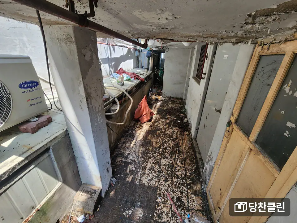 바닥에 오물과 찌꺼기가 깔린 빌라 뒤편 통로